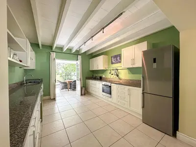 a kitchen with green walls and a stainless steel refrigerator at The hidden Retreat on Haumann in Franschhoek