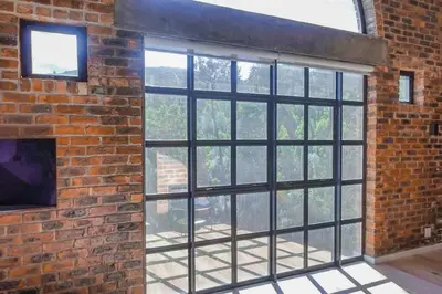 a brick wall with large windows in a room at Tranquil Loft Design and Underground Parking in Stellenbosch