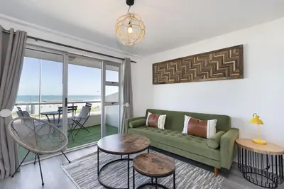 a living room with a couch and a table at Sea Spray B104 in Table View