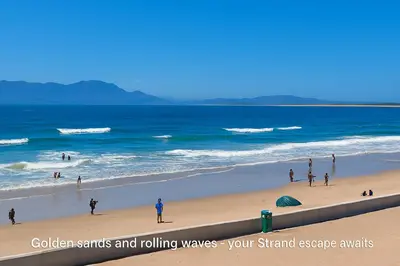 a group of people on a beach near the ocean at Beachfront Luxury Apartment - Hibernian Towers 309 Strand - Self Catering in Cape Town