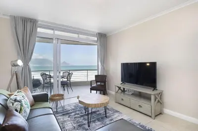 a living room with a couch and a flat screen tv at Portico 405 in Bloubergstrand