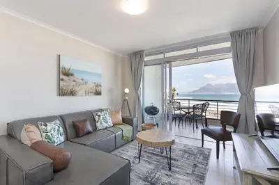a living room with a couch and a view of the ocean at Portico 405 in Bloubergstrand
