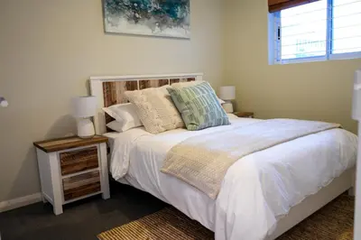 a bedroom with a white bed with pillows and a window at Portico 1002 in Cape Town