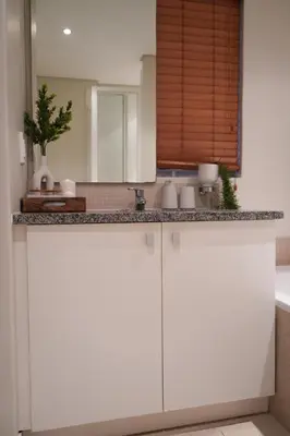 a bathroom with white cabinets and a sink at Portico 1002 in Cape Town
