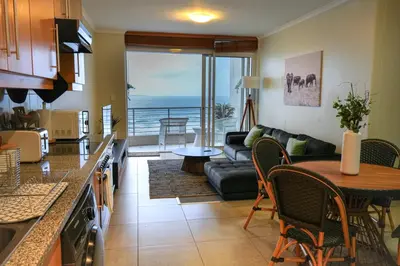 a kitchen and living room with a view of the ocean at Portico 1002 in Cape Town