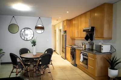 a kitchen with a table and chairs in a room at Portico 1002 in Cape Town