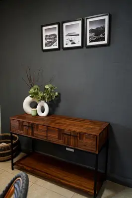 a wooden table with three pictures on a wall at Portico 1002 in Cape Town