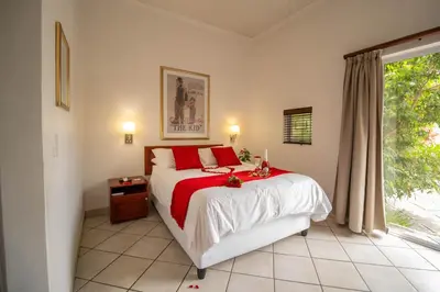 a bedroom with a large bed and a window at Broadway Boston in Cape Town