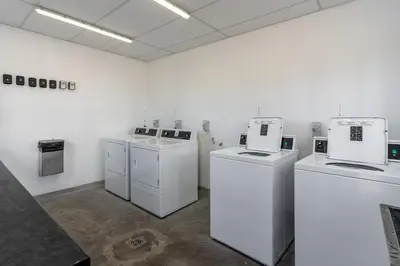 a room with white washers and dryers in a room at Burmeister 606 - Top Floor 2 Bedroom Apartment with Ocean Views - Onsite Parking in Cape Town