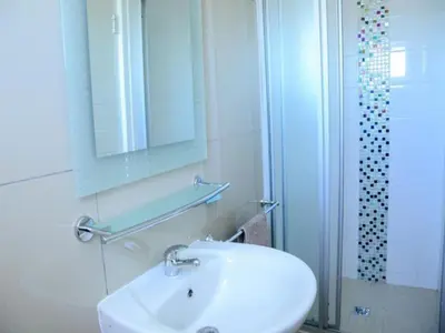 a bathroom with a sink and a mirror and a shower at The Brookston in Cape Town