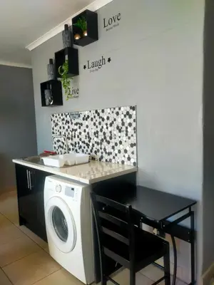 a laundry room with a washing machine and a counter at Elite Escape in Cape Town