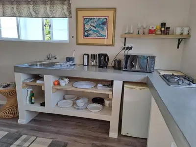 a kitchen with a sink and a counter with plates at Milky Way in Hermanus