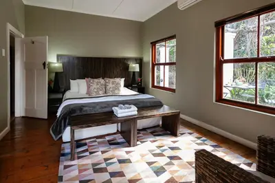 a bedroom with a bed and a table and windows at Leipzig Country House & Winery in Nuy
