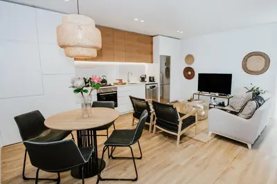 a kitchen and living room with a table and chairs at Quiet Hideaway in Somerset West