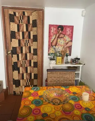 a room with a bed with a picture on the wall at Tranquil Olive Tree Garden Apartment 2 in Cape Town