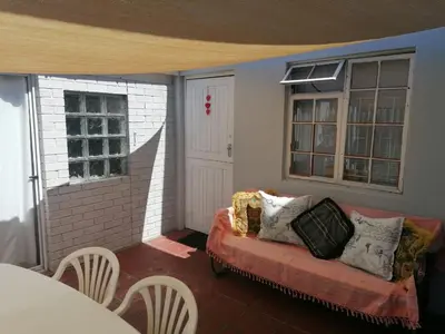 a living room with a couch and two windows at HARTSRUS in Kleinmond