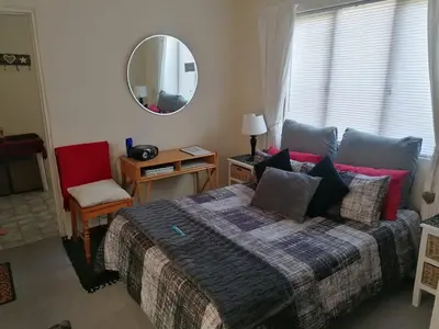a bedroom with a bed and a mirror at HARTSRUS in Kleinmond