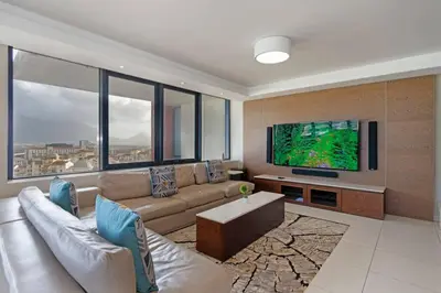 a living room with a couch and a flat screen tv at Grand Penthouse / Backup Power / Stunning in Cape Town