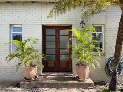 a house with two palm trees in front of a door at 4 on Belmont Avenue in Somerset West