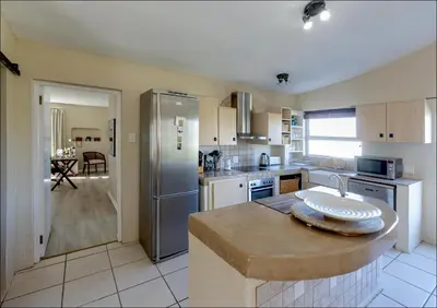 a kitchen with a refrigerator and a sink in it at Sunset Terrace in Hermanus