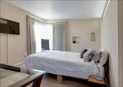 a bedroom with a large bed and a window at Sunset Terrace in Hermanus