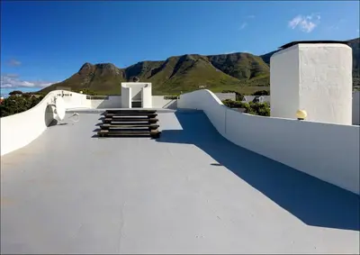 a cross on a building with mountains in the background at Sunset Terrace in Hermanus