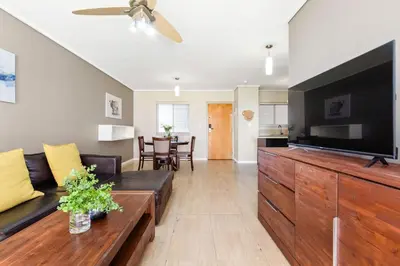 a living room with a couch and a flat screen tv at Lagoon Beach 29A in Cape Town