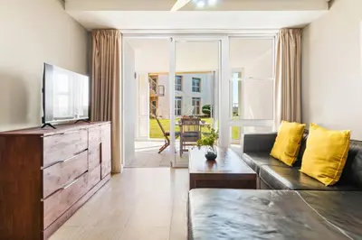 a living room with a couch and a television at Lagoon Beach 29A in Cape Town