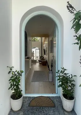 a hallway with two potted plants and an archway at 2 Riverside Oaks in Franschhoek