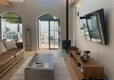 a living room with a couch and a table at 2 Riverside Oaks in Franschhoek