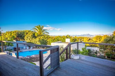 a balcony with a view of a swimming pool at Villa Luisa: Sun-filled hidden gem with Pool. in Cape Town