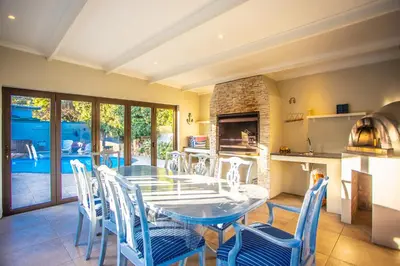 a kitchen and dining room with a table and chairs at Villa Luisa: Sun-filled hidden gem with Pool. in Cape Town