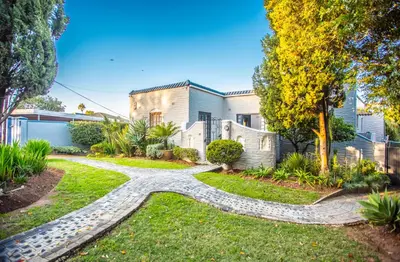 a house with a gravel path in the yard at Villa Luisa: Sun-filled hidden gem with Pool. in Cape Town