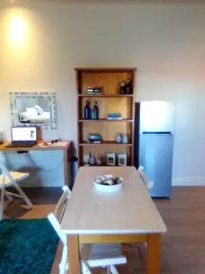 a kitchen with a table and a blue refrigerator at Hermanus Waterfront Apartment 12 in Hermanus