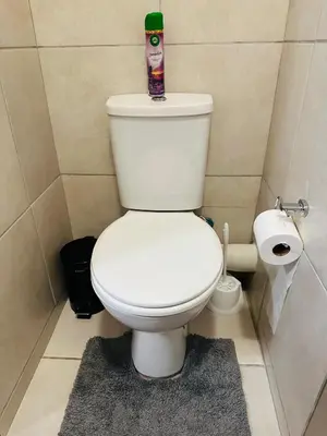 a bathroom with a toilet with a bottle on top of it at Delightful Retreat in Parklands,Cape Farms,Cape Town in Cape Town