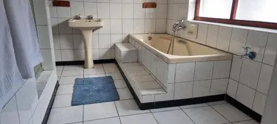 a bathroom with a tub and a sink and a bath tub at McSheyson Apartment - Deluxe in Cape Town