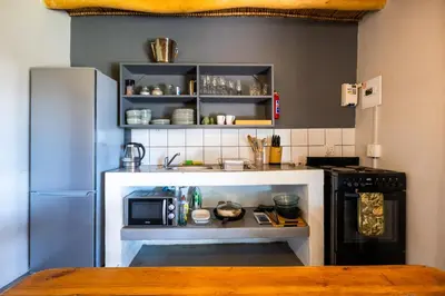 a small kitchen with a stove and a microwave at Dorpsig Cottage in Paarl
