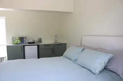 a bedroom with a white bed and a sink at Digital Nomad's Nest, Somerset West in Cape Town