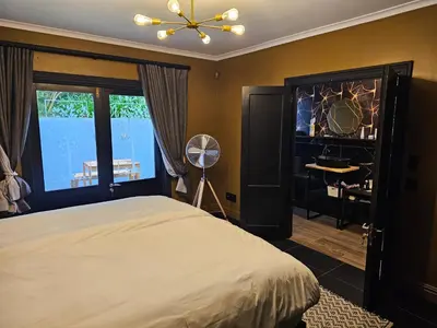 a bedroom with a bed and a ceiling fan at Die Heerenhuys Guest Suites in Stellenbosch