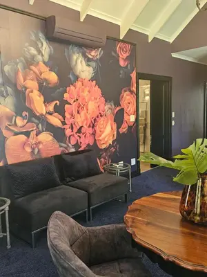a living room with a painting of flowers on the wall at Die Heerenhuys Guest Suites in Stellenbosch