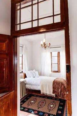 a bedroom with a bed and a chandelier at La Bri Guesthouse in Rawsonville