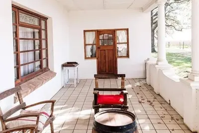 a room with two chairs and a door and windows at La Bri Guesthouse in Rawsonville