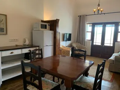 a kitchen and dining room with a table and a refrigerator at Endless Vineyards at Wildekrans Wine Estate in Botrivier