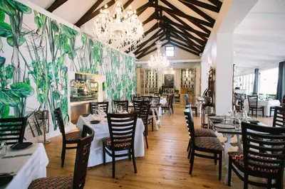 a dining room with tables and chairs and a chandelier at Endless Vineyards at Wildekrans Wine Estate in Botrivier