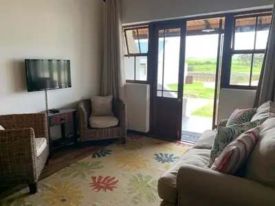a living room with a couch and a tv at Endless Vineyards at Wildekrans Wine Estate in Botrivier