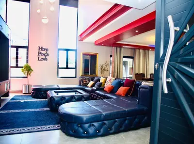 a living room with a blue leather couch at Enclaves Villa in Cape Town