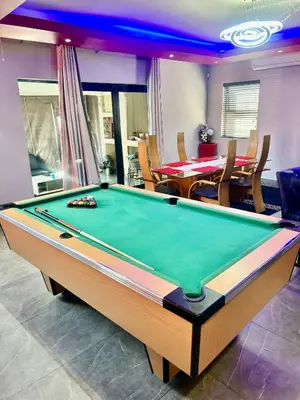 a pool table in a room with a dining room at Enclaves Villa in Cape Town