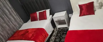 two beds with red pillows in a room at Excel accommodation in Cape Town