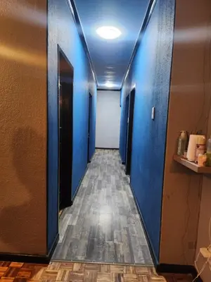 a hallway with blue walls and wooden floors at Excel accommodation in Cape Town