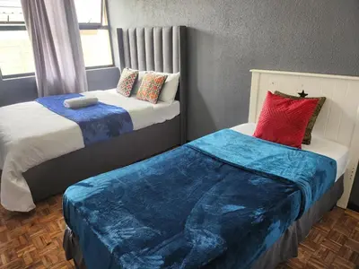 two beds sitting next to each other in a room at Excel accommodation in Cape Town